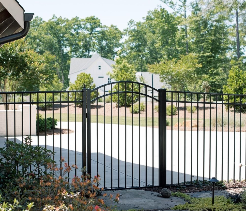Black metal swing driveway gate with arched design in Nashville.